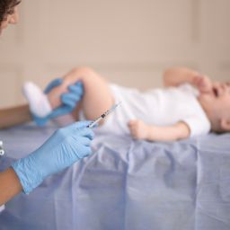 Healthcare professional administering a vaccine to an infant during a pediatric visit