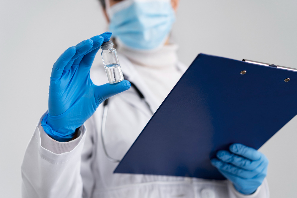 Healthcare professional holding a vaccine vial and clipboard during vaccine inventory review