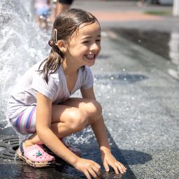 little girl playing in water during summer