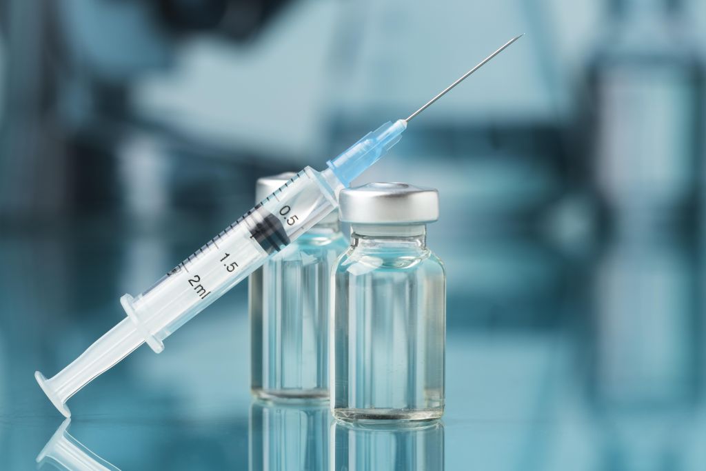 Syringe and vaccine vials in a medical setting, representing vaccine administration, immunization safety, and healthcare best practices.